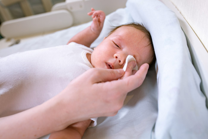 Madre limpiando los ojos de su bebé