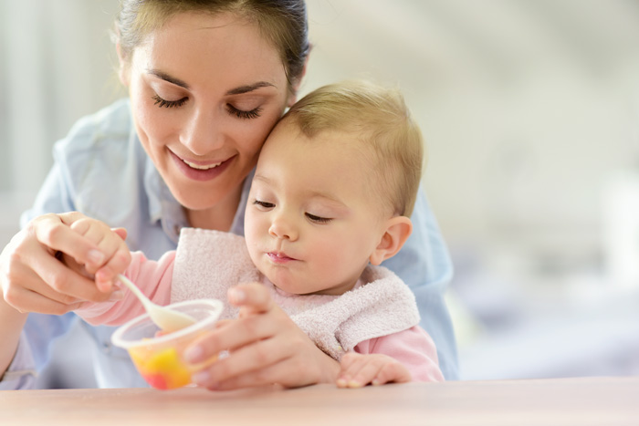 Madre dando de comer a su bebé