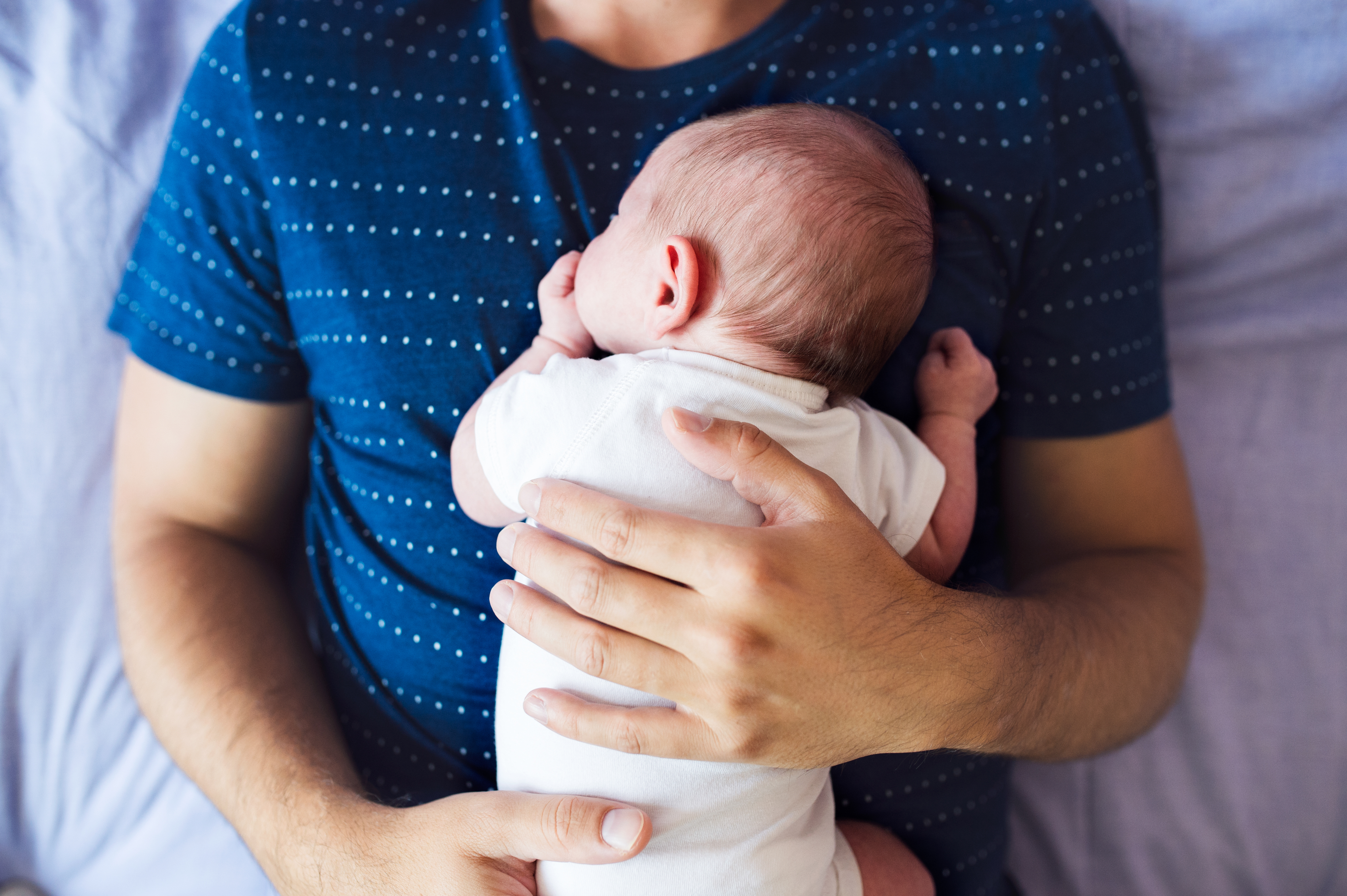 Padre ayudando a fortalecer el cuello de su bebé