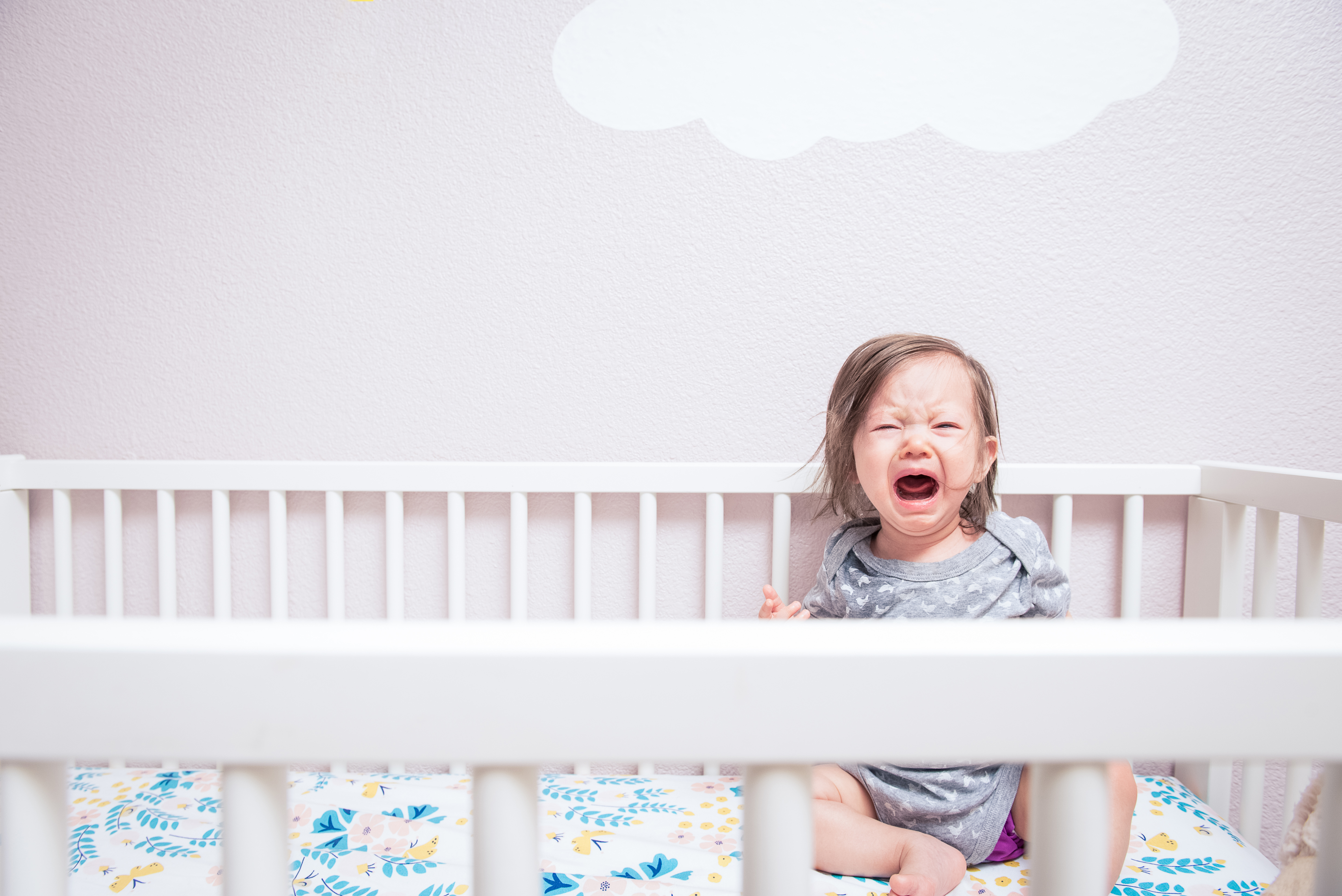 Niña despierta en su cuna llorando