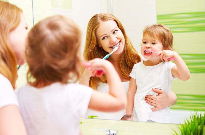 Madre e hija lavándose los dientes