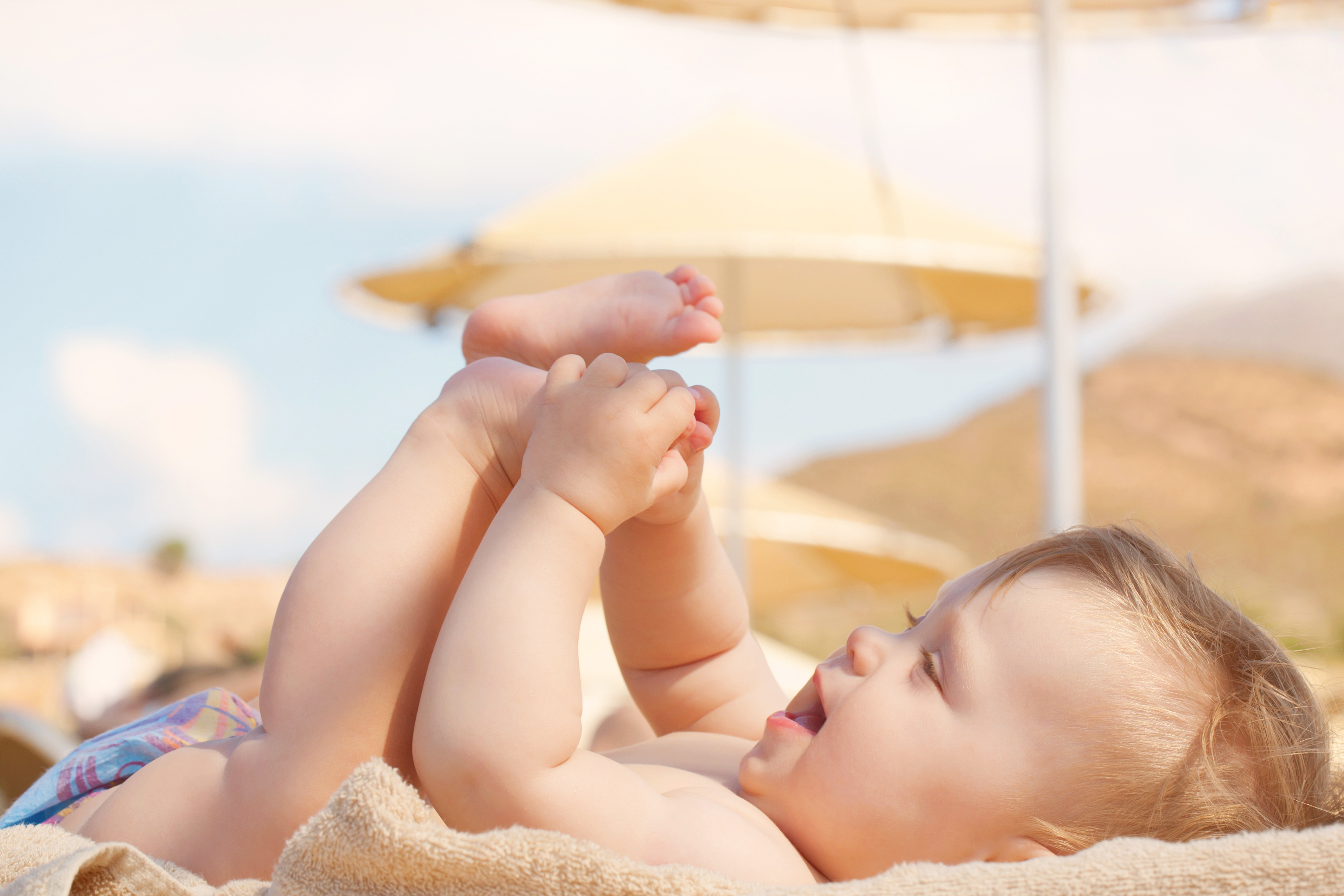 Bebé bajo una sombrilla en la playa